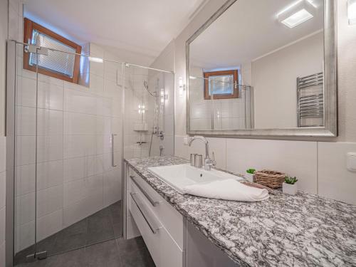 a white bathroom with a sink and a mirror at Kitz Apartments Top 6 in Kitzbühel
