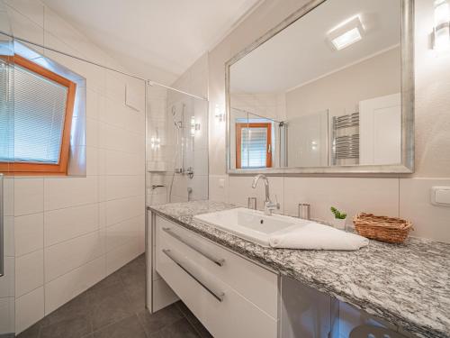 a white bathroom with a sink and a mirror at Kitz Apartments Top 7 in Kitzbühel
