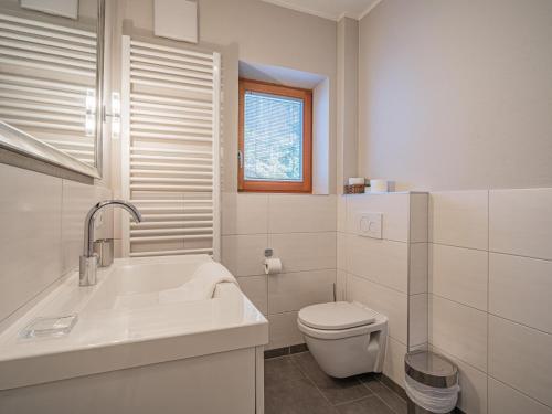 a white bathroom with a toilet and a sink at Kitz Apartments Top 1 in Kitzbühel