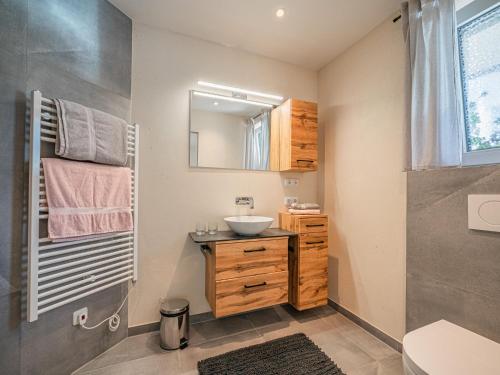 a bathroom with a sink and a mirror at AlpenHerz in Jochberg