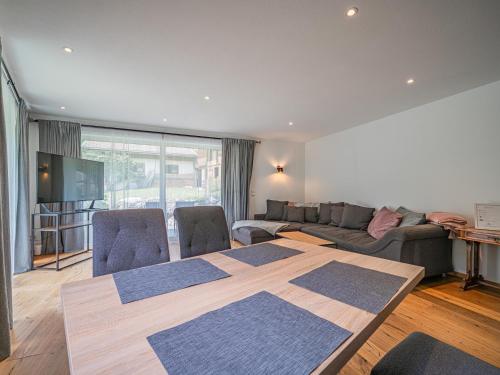 a living room with a table and a couch at AlpenHerz in Jochberg