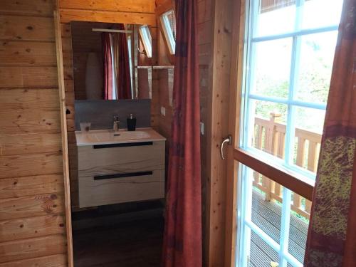 a bathroom with a sink and a window in a cabin at Le Temps-Passe in Saint-Jean-d'Aulps