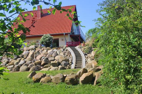 a house with a red roof and a bunch of rocks at Haus an der Wiek in Wohlenberg