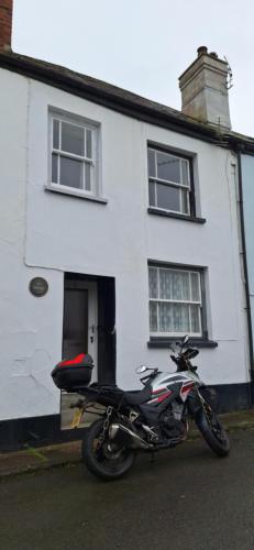a motorcycle parked in front of a white house at Lee Cottage Appledore in Appledore