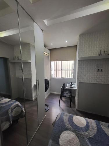 a bedroom with a bed and a glass wall at Recanto de Paz Lapa - RJ in Rio de Janeiro