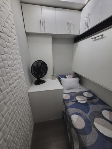 a small room with a bed and white cabinets at Recanto de Paz Lapa - RJ in Rio de Janeiro