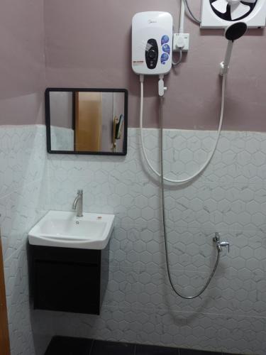 a bathroom with a white sink and a shower at IA Tiny House 2 in Dungun