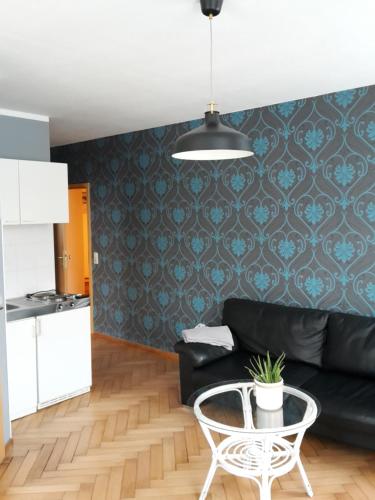 a living room with a black couch and a table at Landhotel zur guten Quelle in Eisenach