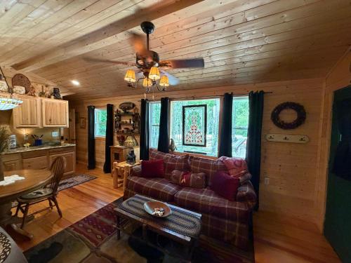 a living room with a couch and a table at Little Bear Tiny Cabin in Cosby