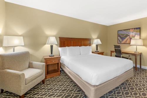 a hotel room with a bed and a chair at Best Western Plus Wooster Hotel & Conference Center in Wooster
