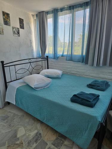 a bedroom with a bed with blue sheets and pillows at Stefanos' Art House in Halikounas