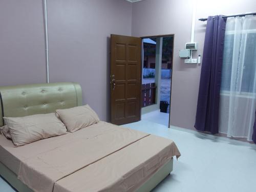 a bedroom with a bed and a door to a room at IA Tiny House in Kampong Sura Tengah