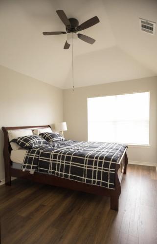 a bedroom with a bed with a ceiling fan at Pet friendly Spacious 4 Bedroom home with large, fenced backyard, located to DFW airport, restaurants and shops in Irving