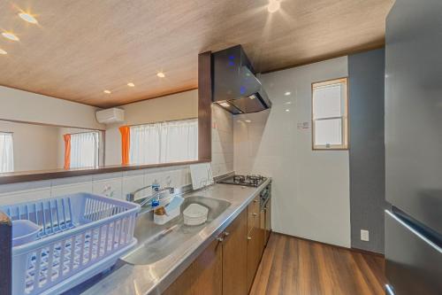 a large kitchen with two sinks and a stove at Third Place Villa KISARAZU in Kisarazu