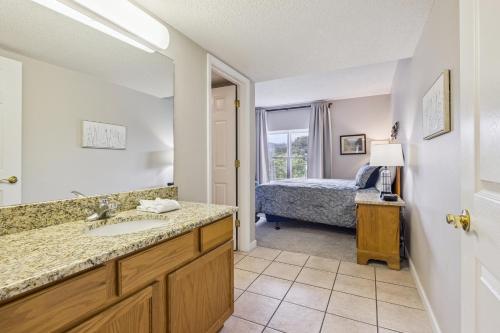 a bathroom with a sink and a bedroom with a bed at WP521 We've Got It All in Pigeon Forge