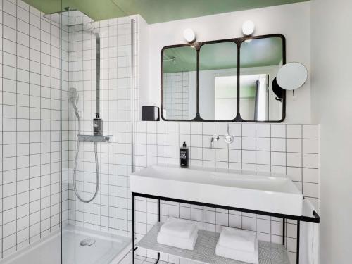 a white bathroom with a sink and a mirror at ibis Styles Amiens Centre in Amiens