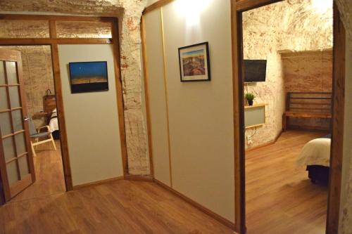 
an open door leading to a room with a wooden floor at Dug Out B&B Apartments in Coober Pedy
