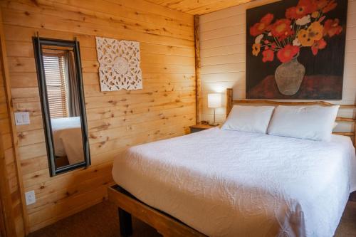 a bedroom with a bed in a wooden cabin at Fireside Cabins in Pagosa Springs