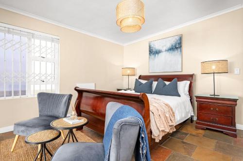 a bedroom with a bed and a chair at Sea Haven 4 in Gordonʼs Bay