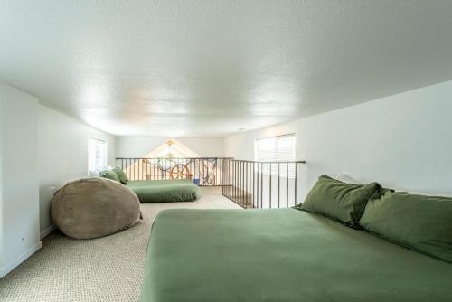 a bedroom with two green beds and a balcony at Emmanuel in Fort Bragg