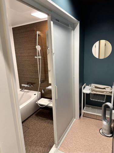 a bathroom with a tub and a toilet and a sink at ハーミットクラブ in Goto