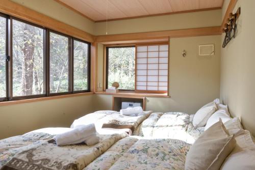 a room with two beds in a room with windows at Wolke Lodge in Shinano