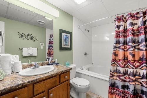 a bathroom with a sink and a toilet and a shower curtain at WP231 Old Mill Overlook in Pigeon Forge