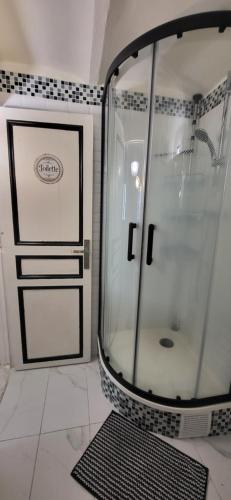a glass shower in a bathroom with a tile wall at Appartement Chaleureux avec Jardin proximité Métro in Marseille
