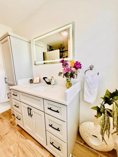 a bathroom with a white sink and a mirror at Oceanside Manor - Ocean View in Qualicum Beach