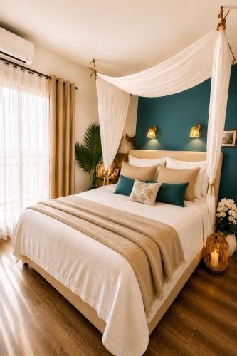 a bedroom with a large white bed with blue walls at Ocean Eleven Boutique Stay - Sea View Sunset Terrace in Sainte-Anne