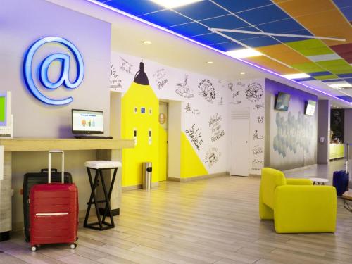 an office with a waiting area with luggage and a building on the wall at ibis Budget Barranquilla in Barranquilla