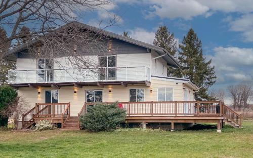 a large white house with a large deck at Orchard Haven in Orono