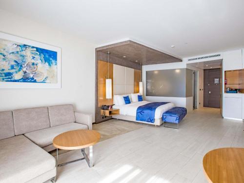a hotel room with a bed and a couch at Mövenpick Hotel du Lac Tunis in Tunis