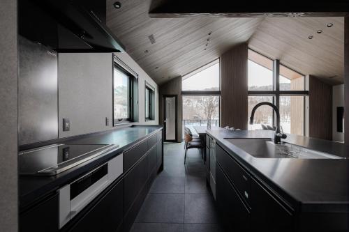 a kitchen with a large sink and a large window at Forest Resort Walnut in Hakuba