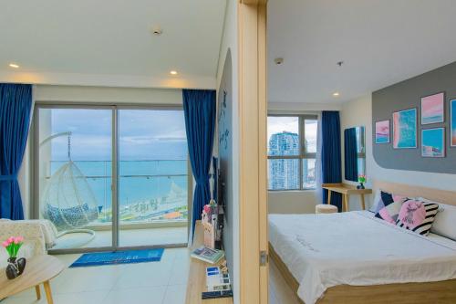 a bedroom with a bed and a large window at The Sóng Infinity Pool Apartment Vung Tau Near Beach in Vung Tau