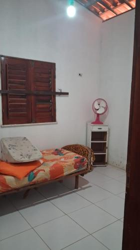 a bedroom with a bed and a clock on the wall at Casa de praia Morro Branco in Beberibe