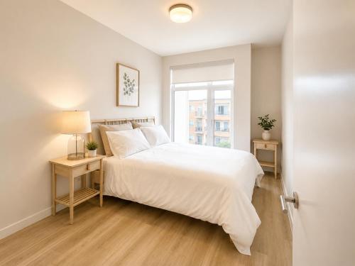a bedroom with a white bed and a window at Lovely Brand New Condo in Sidney
