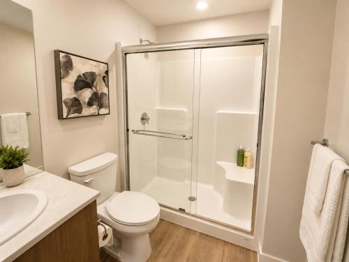 a bathroom with a shower and a toilet and a sink at Lovely Brand New Condo in Sidney