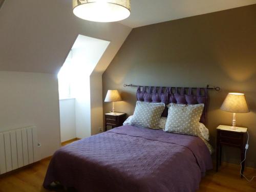 a bedroom with a purple bed with two lamps at Gîte de charme à la campagne - 6 pers. - FR-1-489-17 in Bagneux