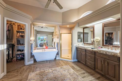 a bathroom with two sinks and a tub and two mirrors at Lake House in Fort Mohave