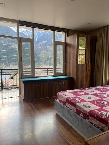 a bedroom with a bed and a large window at Monkeys Junction in Manāli