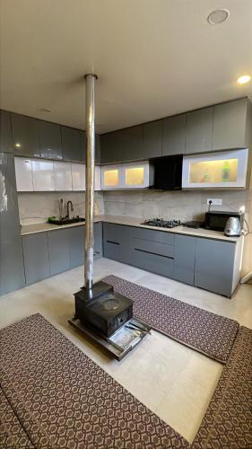 a kitchen with a stove in the middle of a room at Monkeys Junction in Manāli