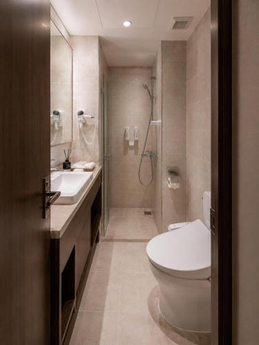 a bathroom with a toilet and a sink and a shower at Gold Coast Hotel Incheon in Incheon