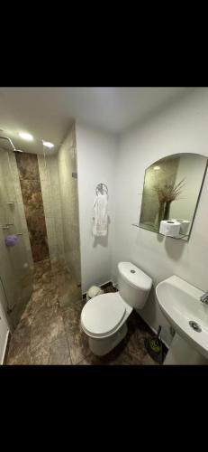 a bathroom with a toilet and a sink and a shower at Hostal CAMPOAMOR in Medellín