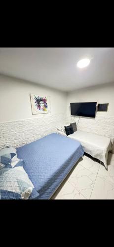 a bedroom with a large bed and a tv at Hostal CAMPOAMOR in Medellín