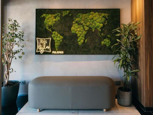 a couch in a room with a picture of grapes at Ibis Styles Figueres Ronda in Figueres