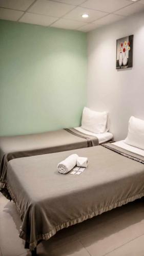 two beds in a room with towels on them at ML SUITES CEBU in Cebu City