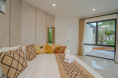 a living room with a large bed and a table at Sanara Oasis Villa in Canggu