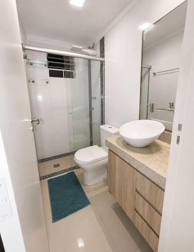a white bathroom with a toilet and a sink at apartamento Seminate 2 in Franca