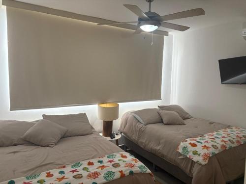a bedroom with two beds and a ceiling fan at Relax Terrace Condo Near Coronado Beaches in El Creo